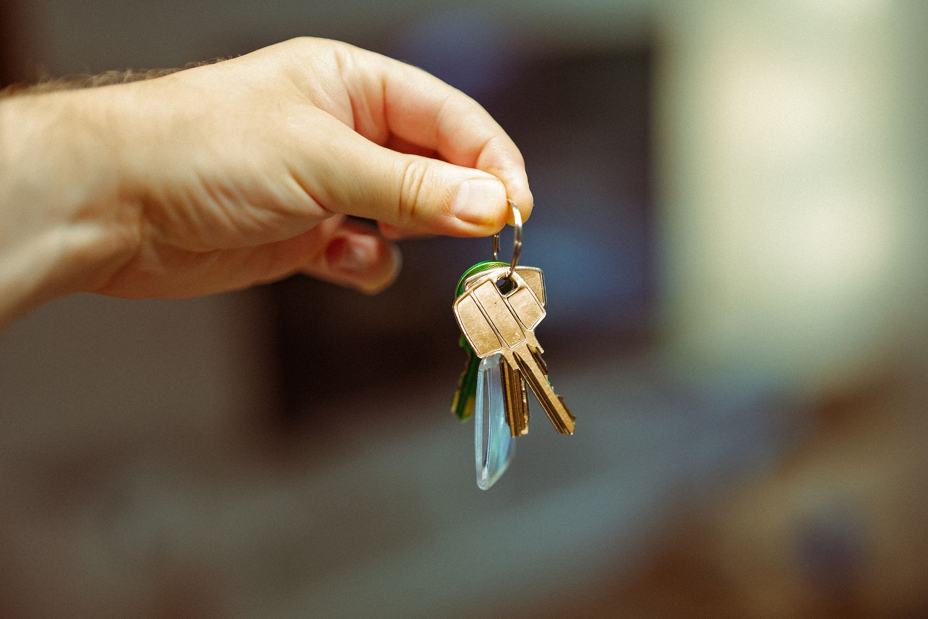 Hand holding house keys after unit handover